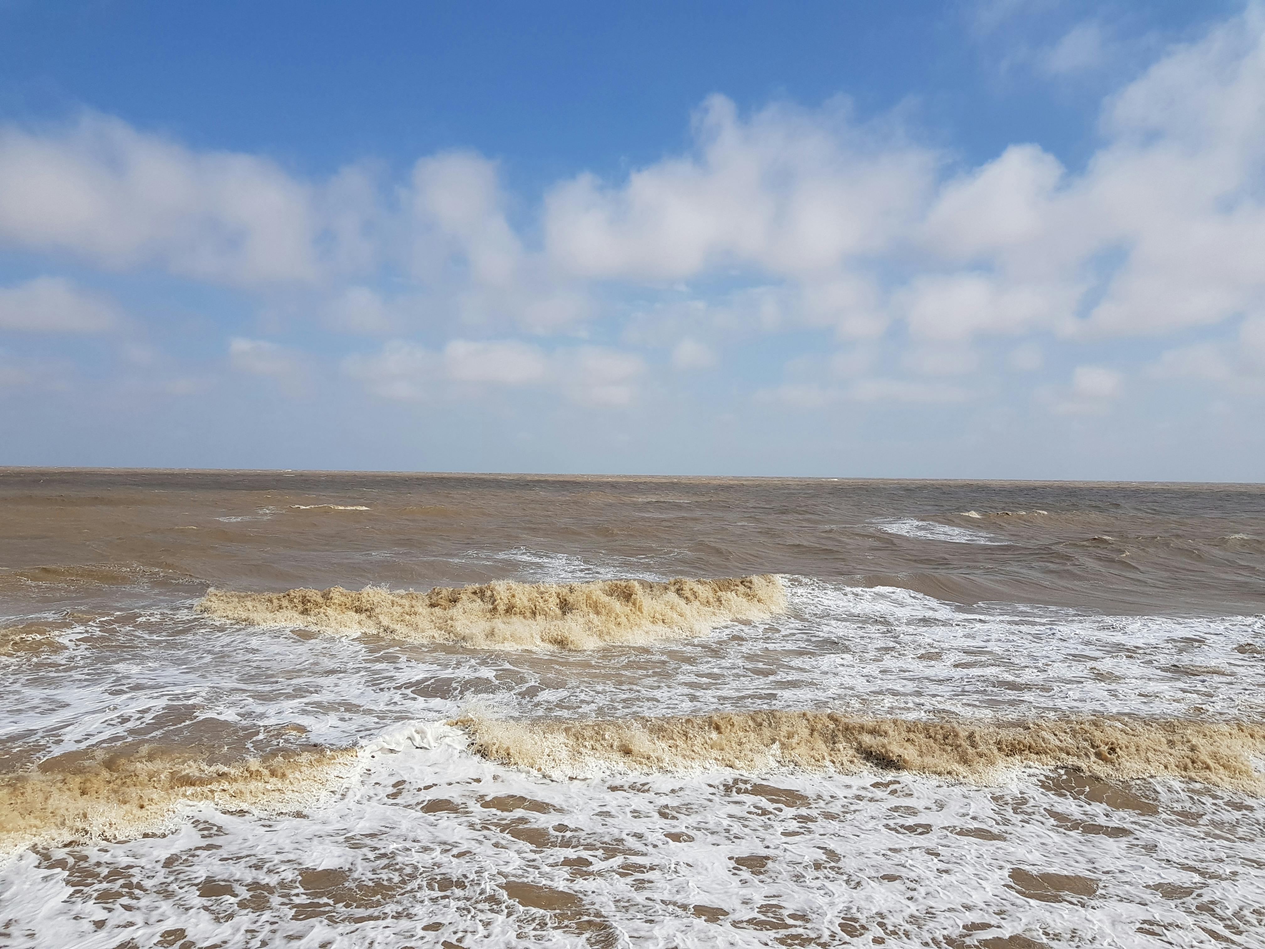 Peaceful ocean view with waves near Walton-on-the-Naze, England under a clear sky.